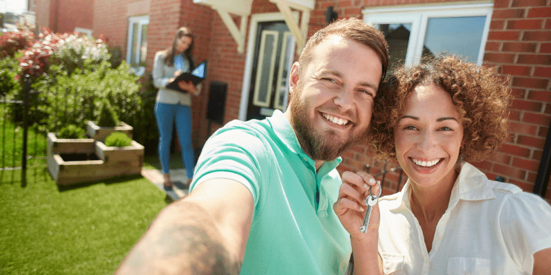 New homeowners smiling holding keys.