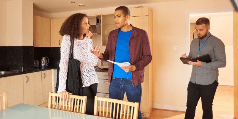 One person asking can a buyer back out before closing to another person in a kitchen with an agent nearby.